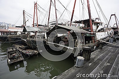 Fishing boats are at the wooden pier in the port of Macau.