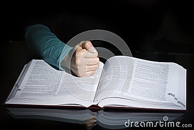Fist over open book
