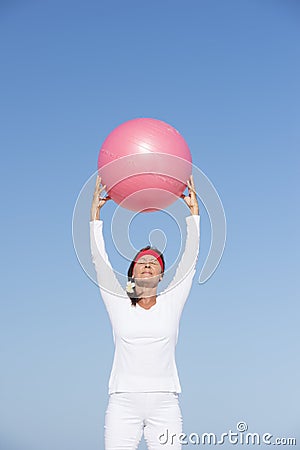 Fit and active senior woman exercising with ball