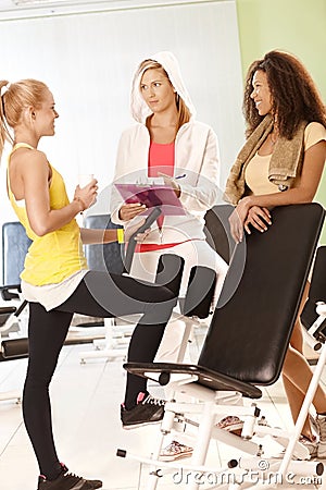 Fit girls and personal trainer at the gym