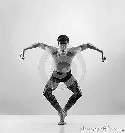 Fit male ballet dancer on a grey background