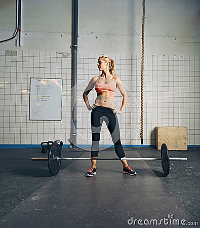 Fit young woman at gym with barbell