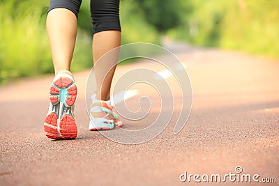 Fitness woman legs running at forest trail