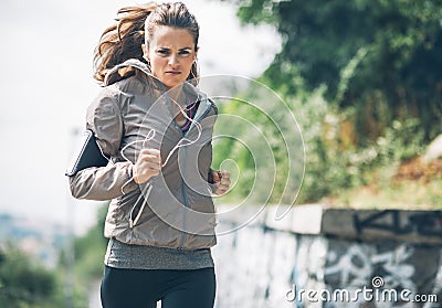 Fitness young woman jogging in the city park