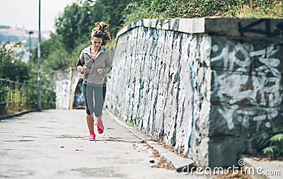 Fitness young woman jogging in the city park