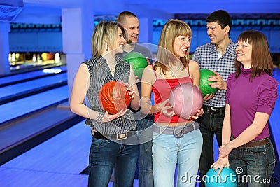 Five friends stand with balls for bowling