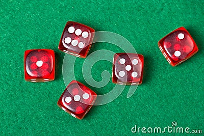 Five red dices on green table