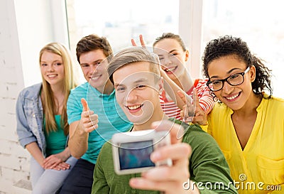 Five smiling students taking picture with camera