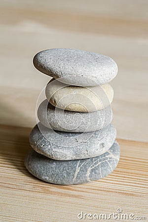 Five spa zen stones stacked on a wood background