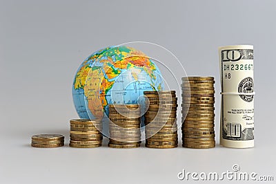 Five stacks of coins with a globe and a bundle of dollars