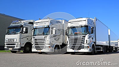Fleet of White Scania and Volvo Trucks on a Yard