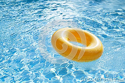Floating ring on blue water swimpool with waves reflecting