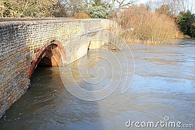 Flood water under a stone bridge.