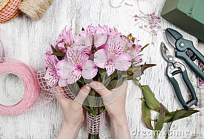 Florist at work: woman arranging bouquet of alstroemeria flowers