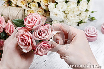 Florist at work. Woman making bouquet of pink roses