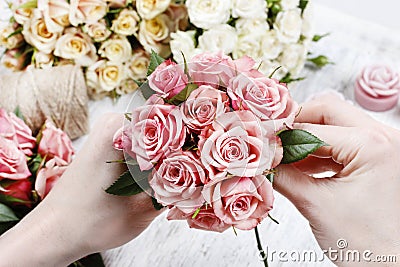 Florist at work. Woman making bouquet of pink roses