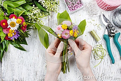Florist at work. Woman making bouquet of wild flowers