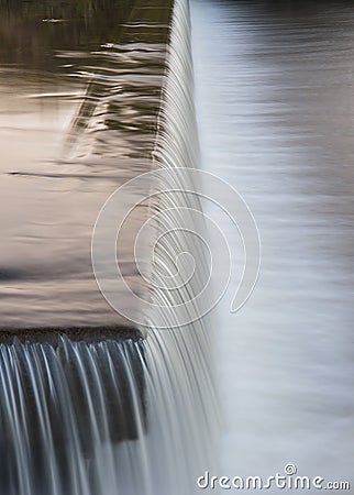 Flowing water cascading over a weir on yorkshire river