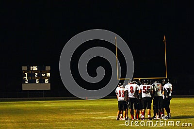 Football huddle at night game