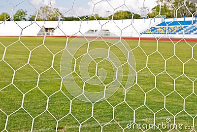 Football net on green grass background