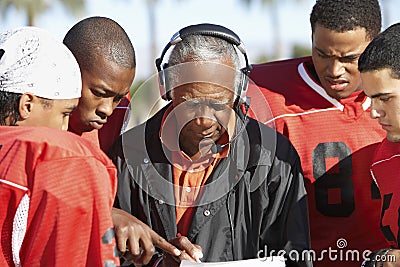 Football Players And Coach Discussing Strategy