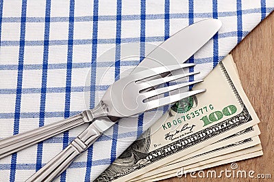 Fork and knife on dollar bills