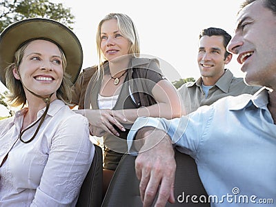Four Happy Tourists Sitting In Jeep