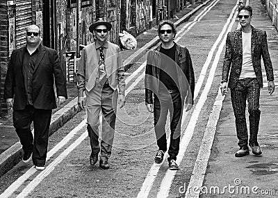 Four men walking down the road
