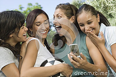 Four Women Laughing At Mobile Phone Display