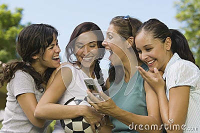 Four Women Laughing At Mobile Phone Display