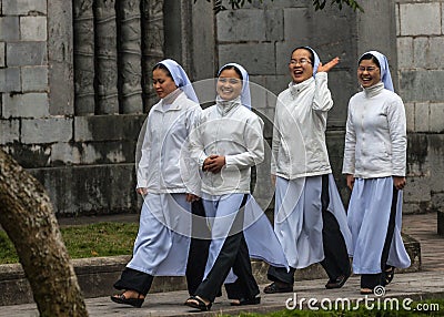 Four young Vietnamese nuns in Ao Dai going to church service.