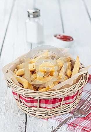 French fries in a wicker basket on white table - bar or fast food menu