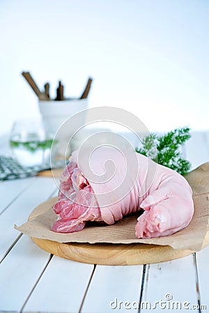 Fresh pink pork leg with fat on cut board