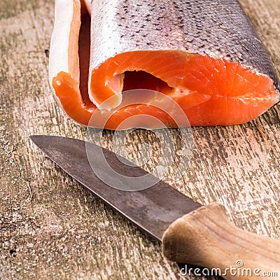 Fresh Salmon with old knife on wooden board