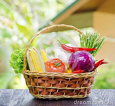 Fresh vegetables in the basket on wooden table