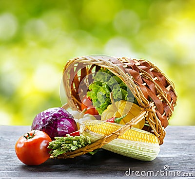 Fresh vegetables in the basket on wooden table