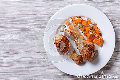 Fried chicken drumsticks with pumpkin, top view