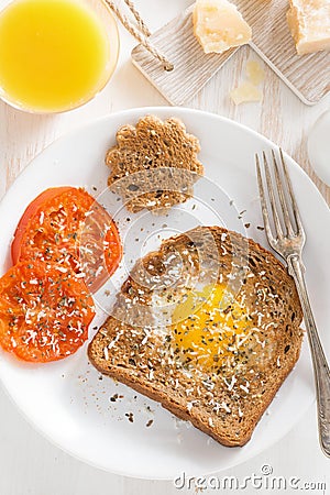 Fried egg in a toast and grilled tomatoes, top view