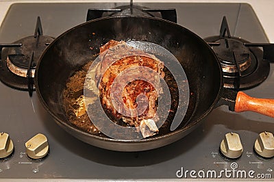 Fried meat on frying pan