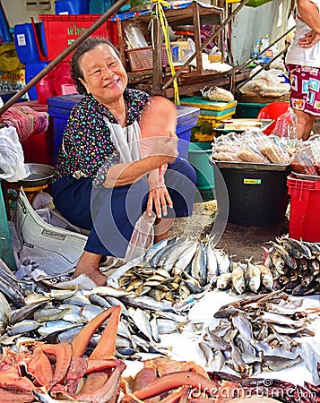 A friendly Thai vendor selling dried fish in a wet market nearby Bangkok
