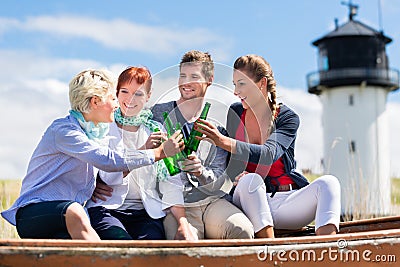 Friends drinking bottled beer at beach
