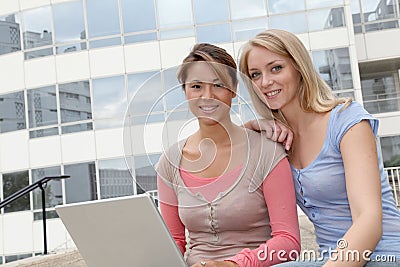 Friends with laptop in front of building