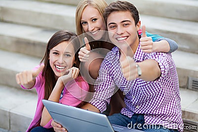Friends with laptop showing thumbs up