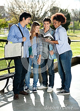 Friends Reading Book Together In College Campus