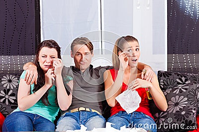 Friends watching a sad movie in TV
