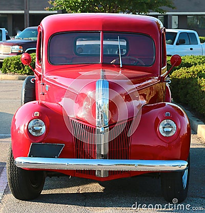 Front view of a 1940 s model Ford 3100 red pick-up truck.