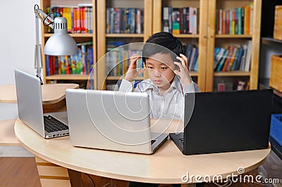 Frustrated boy in white shirt in front of multiple laptop