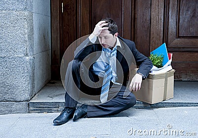 Frustrated business man on street fired with cardboard box