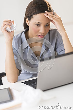 Frustrated Businesswoman Looking At Laptop While Sitting At Desk