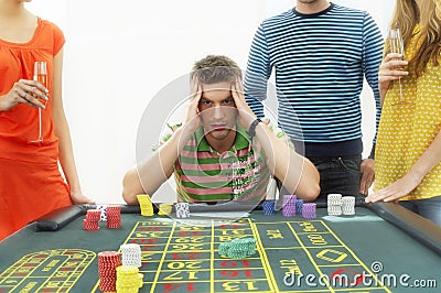 Frustrated Man At Roulette Table With Friends